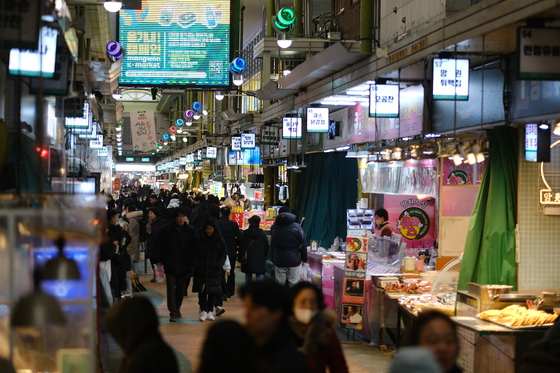 Customers walk around a traditional market in Seoul on Jan. 15. [YONHAP] 