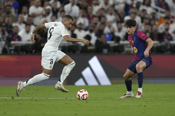 Real Madrid forward Kylian Mbappe, left, dribbles the ball during the Spanish Super Cup final against Barcelona at King Abdullah Stadium in Jeddah, Saudi Arabia on Jan. 12. [AP/YONHAP] 