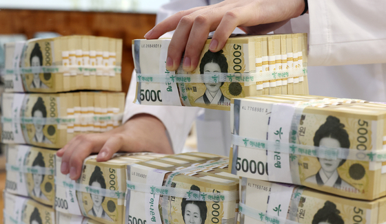 An employee arranges stacks of 50,000-won ($34) bank notes at Hana Bank's Counterfeit Notes Response Center in Jung District, central Seoul, on July 17, 2024. [NEWS1]