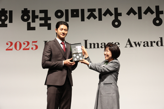 Fencer Oh Sang-uk, left, receives an award from President of Corea Image Communication Institute Choi Jung Hwa, at the Korea Image Awards on Wednesday at Grand InterContinental Seoul Parnas in Gangnam District, southern Seoul. [COREA IMAGE COMMUNICATION INSTITUTE] 