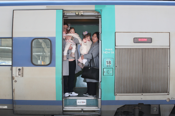 A family on board the high-speed KTX train waves to the camera during the 2024 Lunar New Year. [NEWS1]