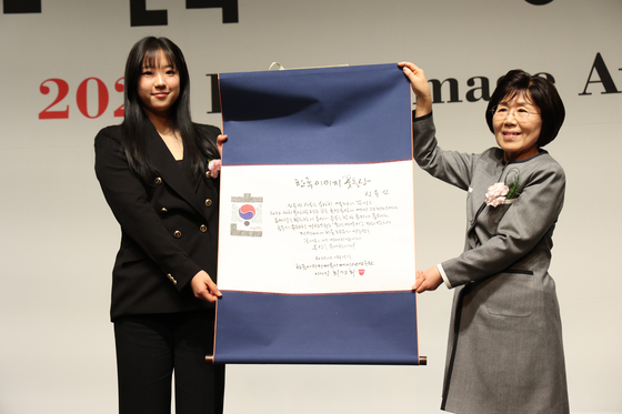 Table tennis player Shin Yu-bin, left, receives an award from President of Corea Image Communication Institute Choi Jung-hwa, at the Korea Image Awards on Wednesday at Grand InterContinental Seoul Parnas in Gangnam District, southern Seoul. [COREA IMAGE COMMUNICATION INSTITUTE]