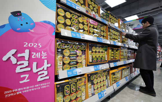 A customer looks at canned ham and tuna gift sets at a Lotte Mart in Gangdong District, eastern Seoul, on Jan. 16. [NEWS1]