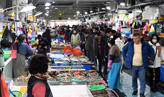Shoppers crowd a market in Jumunjin in Gangneung, Gangwon, to purchase fresh seafood 10 days ahead of the Lunar New Year on Jan. 19. [YONHAP]