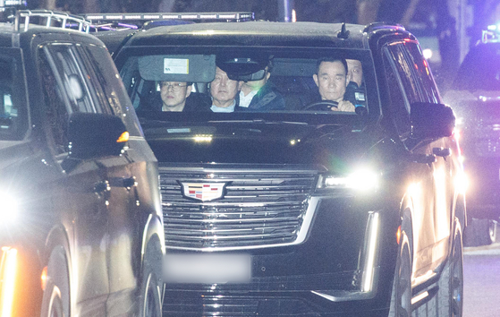 Impeached President Yoon Suk Yeol, center, sits in a car on his way to the Seoul Detention Center in Uiwang, Gyeonggi, after appearing for questioning at the Corruption Investigation Office of High-ranking Officials headquarters in Gwacheon on Jan. 15. [JOINT PRESS CORPS]
