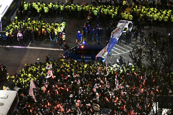 Supporters of President Yoon Suk Yeol rally as a convoy carrying the Korean impeached leader returns to the Seoul Detention Center in Uiwang, Gyeonggi, after an arrest warrant hearing at the Seoul Western District Court on Jan. 18. [JOINT PRESS CORPS]