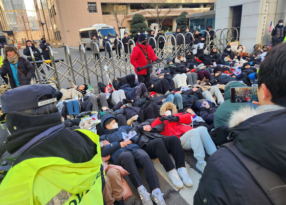 Supporters of President Yoon Suk Yeol are lying on the street in protest of his arrest in front of the Seoul Western District Court in Mapo District, western Seoul, ahead of a warrant hearing. [YONHAP]