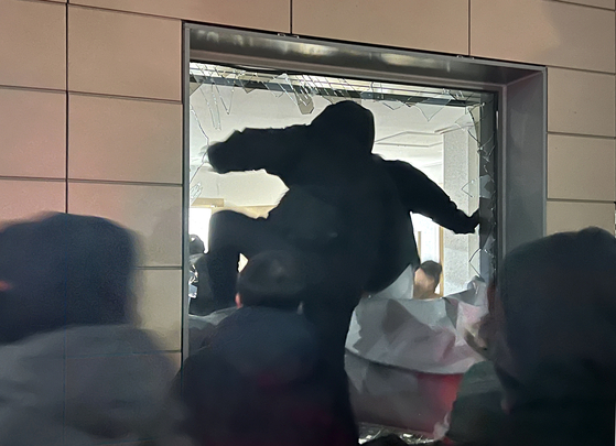 A protester breaks into the window of the Seoul Western District Court in Mapo District, western Seoul, following the issuance of an arrest warrant for impeached President Yoon Suk Yeol on Jan. 19. [NEWS1] 