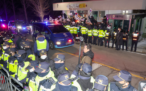 Police stand guard as supporters of President Yoon Suk Yeol gather to watch a convoy carrying the Korean impeached leader return to the Seoul Detention Center in Uiwang, Gyeonggi, after an arrest warrant hearing at the Seoul Western District Court on Jan. 18. [JOINT PRESS CORPS]