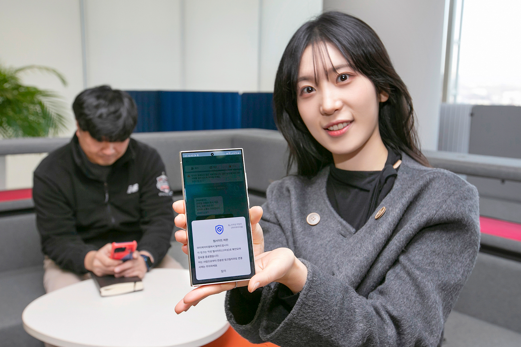 A person holds a phone displaying KT's alerts service against suspected text message scams, on Dec. 17, 2024. [KT]
