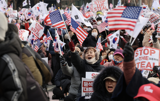 Supporters of President Yoon Suk Yeol hold a rally waving flags of South Korea and the United States near the presidential residence in Hannam-dong in central Seoul on Jan. 12. [LIM HYEON-DONG]