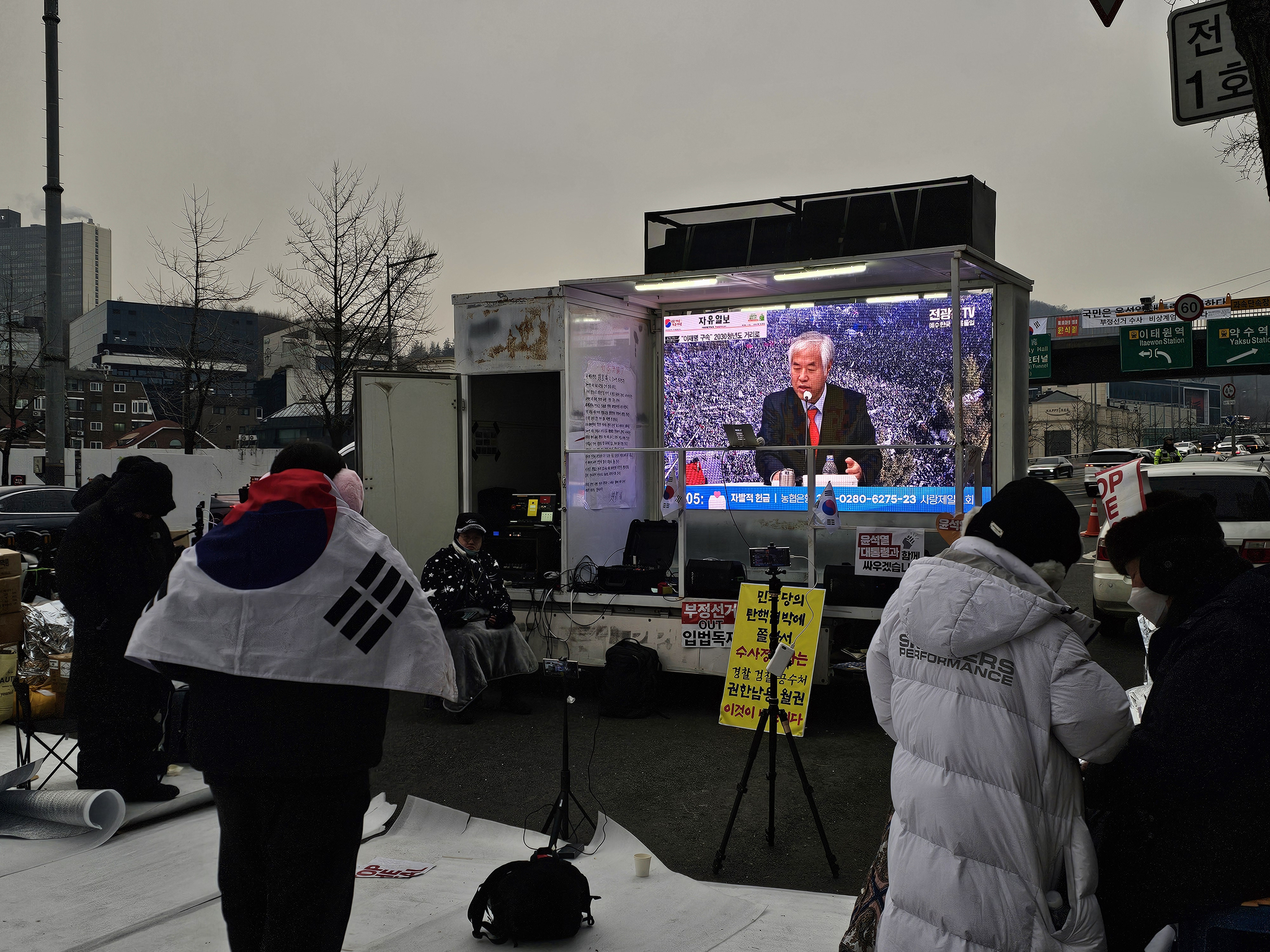 Conservative protesters watch a YouTube clip of right-wing pastor Jeon Kwang-hoon during their rally near President Yoon Suk Yeol's residence in Yongsan District in central Seoul on Jan. 13. [LEE CHAN-KYU]