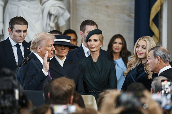 U.S. President-elect Donald Trump, left, is sworn in by Chief Justice John Roberts, right, as Barron Trump, from left, Melania Trump, Ivanka Trump and Tiffany Trump watch at the 60th Presidential Inauguration in the Rotunda of the U.S. Capitol in Washington, Jan. 20. [AP/YONHAP]