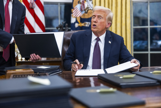 U.S. President Donald Trump signs numerous executive orders on the first day of his presidency on Jan. 20. [EPA/YONHAP] 