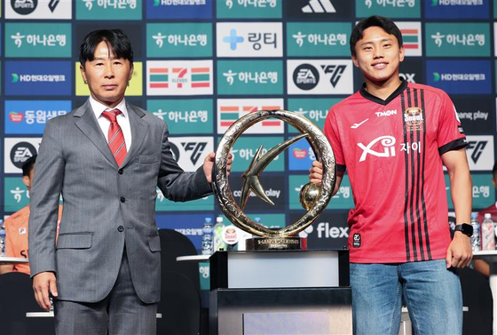 FC Seoul manager Kim Gi-dong, left, poses with the K League 1 trophy with FC Seoul forward Cho Young-wook on Feb. 26, 2024 at the Plaza in central Seoul. [YONHAP]