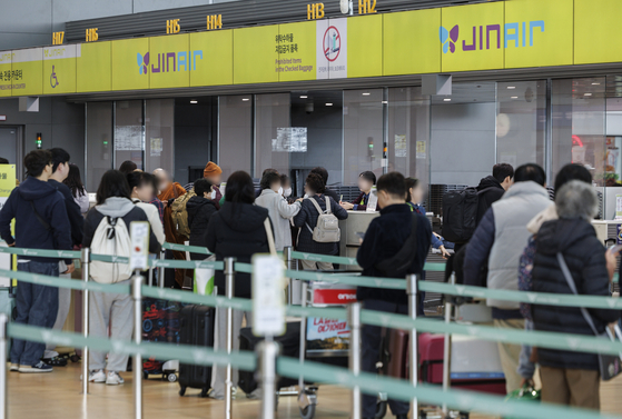 Passengers wait to check in at a Jin Air counter in Incheon International Airport’s Terminal 2 on the afternoon of Jan. 21. The budget airline announced Jan. 20 that it had achieved record revenue of 1.46 trillion won ($1.01 billion) in 2024, with passengers exceeding 10 million for the first time. [YONHAP]