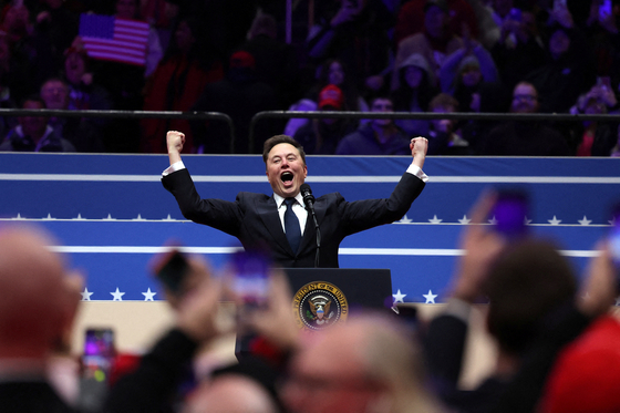 Tesla CEO Elon Musk gestures on stage as he prepares to speak inside the Capital One arena on the inauguration day of Donald Trump's second Presidential term, in Washington, Jan. 20. [REUTERS/YONHAP]