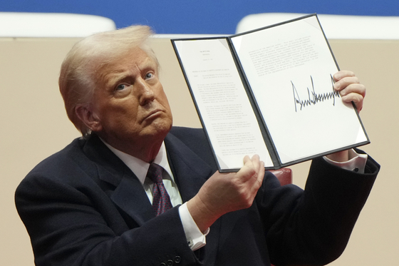 President Donald Trump holds up an executive order after signing it at an indoor Presidential Inauguration parade event in Washington, D.C. on Jan. 20. [AP/YONHAP]