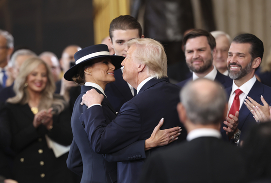 U.S. President Donald Trump, center right, reaches to kiss first lady Melania Trump as Barron Trump, from left, Vice President JD Vance and Donald Trump Jr. watch at the 60th Presidential Inauguration in the Rotunda of the U.S. Capitol in Washington, Jan. 20, 2025. [AP/YONHAP]