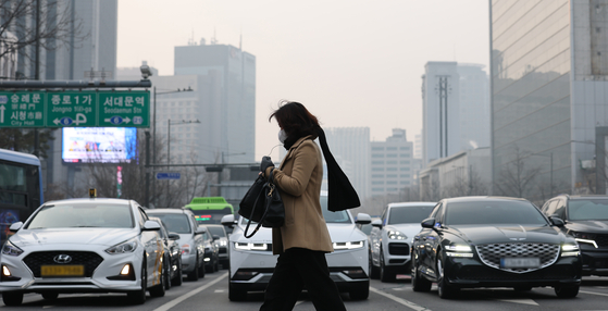 A woman wearing a mask crosses the street in Jongno District, central Seoul, on Jan. 22. [NEWS1]
