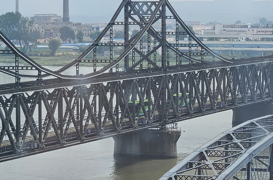 Two buses departing from Sinuiju, North Korea, are seen headed to Dandong, Liaoning Province, China, a border area between North Korea and China, via the Yalu River Bridge on Aug. 16, 2023. [YONHAP]