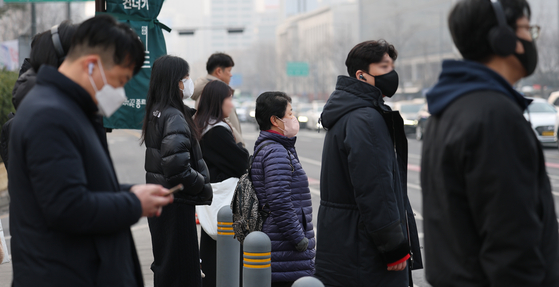 People wearing masks wait to cross the street in Jongno District, central Seoul, on Jan. 22. [NEWS1]