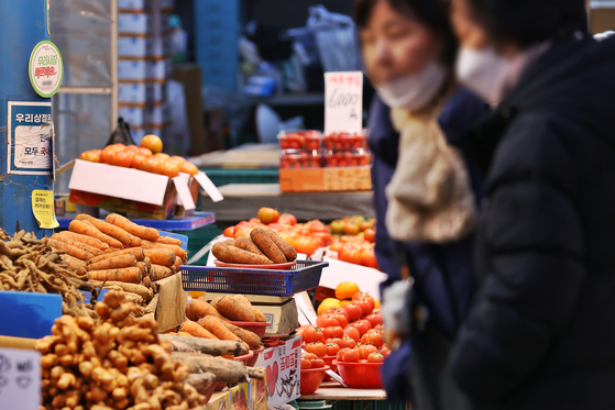 Shoppers browse produce at a traditional market in Seoul on Jan. 23. [YONHAP]