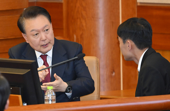 President Yoon Suk Yeol, left, speaks with his attorney during his impeachment trial hearing at the Constitutional Court in Jongno District, central Seoul, on Jan. 23. [JOINT PRESS CORPS]
