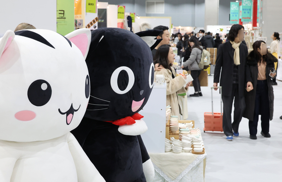 Cat enthusiasts browse a range of products on display at the Nyang Nyang Punch Cat Show at Coex Magok in Gangseo District, western Seoul, on Jan. 26. [YONHAP]