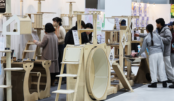 Cat enthusiasts browse a range of products on display at the Nyang Nyang Punch Cat Show at Coex Magok in Gangseo District, western Seoul, on Jan. 26. [YONHAP]