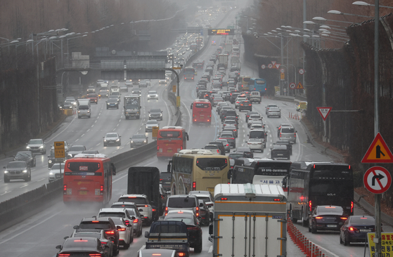 Southbound lanes near Jamwon IC on the Gyeongbu Expressway in Seoul experience heavy congestion on the morning of Jan. 27, as rain and snow fell across the country. [YONHAP]