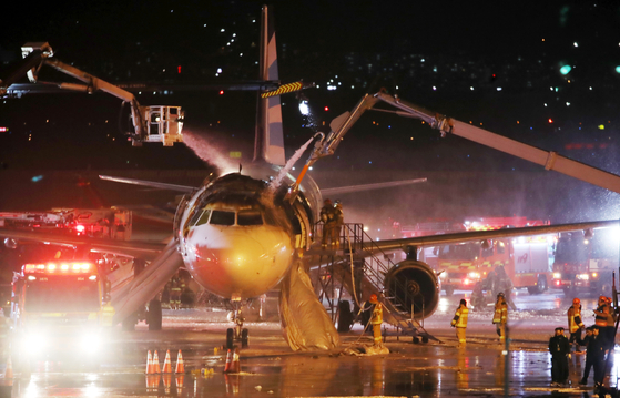 Fire authorities work to extinguish a fire that started while an Air Busan flight was preparing for takeoff from Gimhae Airport in Busan on Jan. 28. [NEWS1]