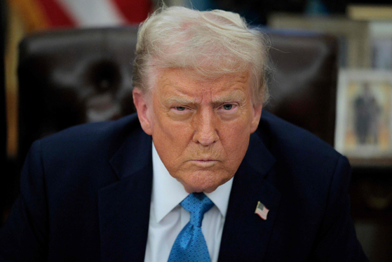 U.S. President Donald Trump talks to reporters after signing an executive order on tariffs against China, Canada and Mexico in the Oval Office on Jan. 31 in Washington. [AFP/YONHAP]