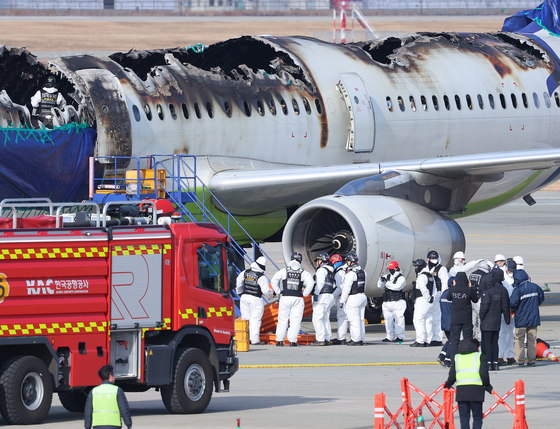 Authorities from the transportation ministry and a French agency in charge of civil aviation accidents begin a joint investigation into a fire-destroyed Air Busan plane on Feb. 3. [YONHAP]