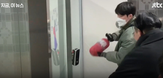The ″green jumper man″ breaks a security device with a fire extinguisher in the Seoul Western District Court in Mapo District, western Seoul, on Jan. 19. [SCREEN CAPTURE]