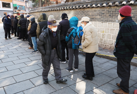 Older adults line up at a soup kitchen outside Tapgol Park in Jongno District, central Seoul, on Feb. 3. [YONHAP]