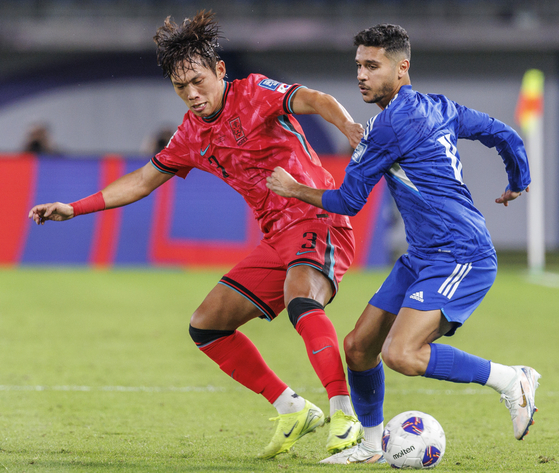 Korea's Lee Myung-jae, left, vies for the ball during the 2026 World Cup qualifier against Kuwait at Jaber Al-Ahmad International Stadium in Kuwait on Nov. 15, 2024. [YONHAP] 