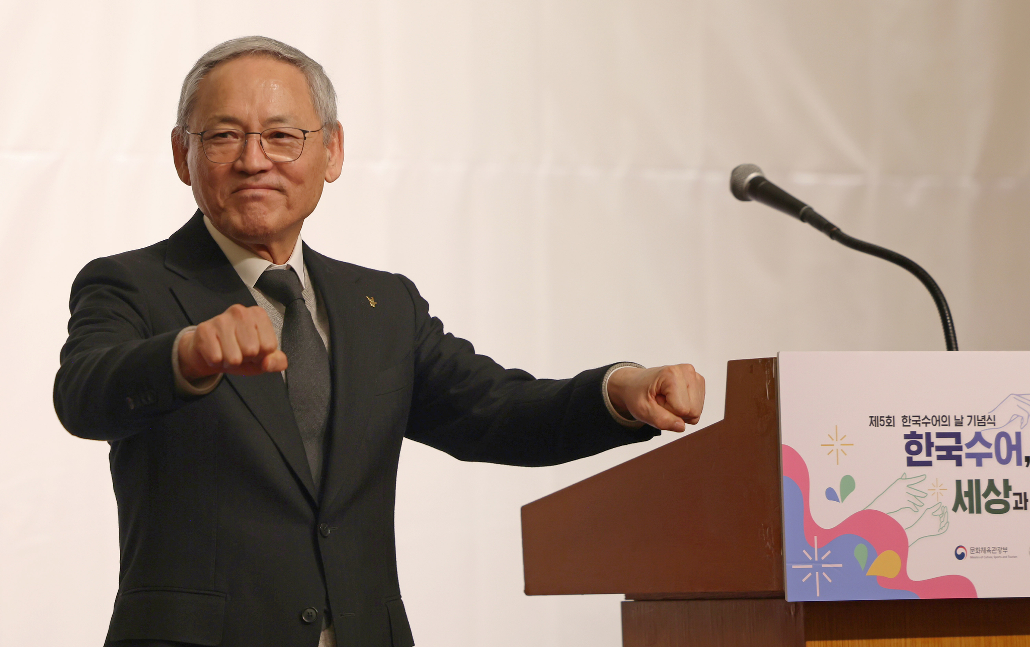 Culture Minister Yu In-chon greets in sign language at the fifth Korean Sign Language Day event in the Swiss Grand Hotel, western Seoul on Feb. 3. [NEWS1]