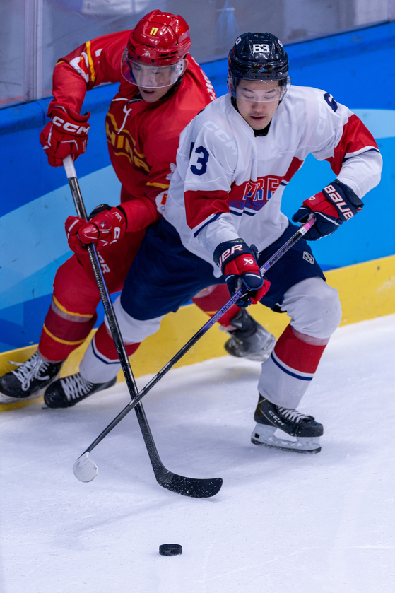Kwon Hyeon-su, right, of Korea views with Zhang Pengfei of China during a men's ice hockey Group A match at the Asian Winter Games in Harbin, China on Feb. 4.  [XINHUA/YONHAP]
