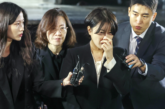 Moon Da-hye, second from right, leaves the Yongsan Police Precinct in Yongsan District, central Seoul, on Oct. 18, 2024, after being questioned by police regarding her involvement in a car accident. [NEWS1]