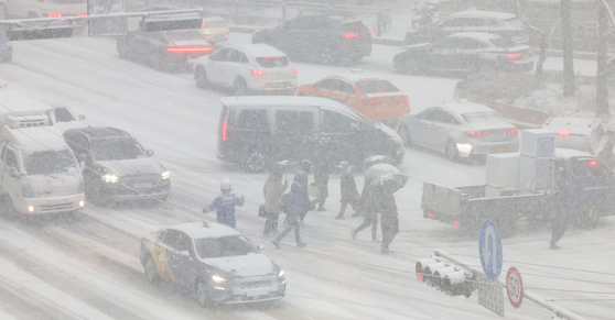 Cars are stuck in traffic amid heavy snow in Jung District, central Seoul, on Feb. 6. Heavy snow advisories were issued in most of the country on Thursday, with some commuters worried over whether they could arrive home. [YONHAP]