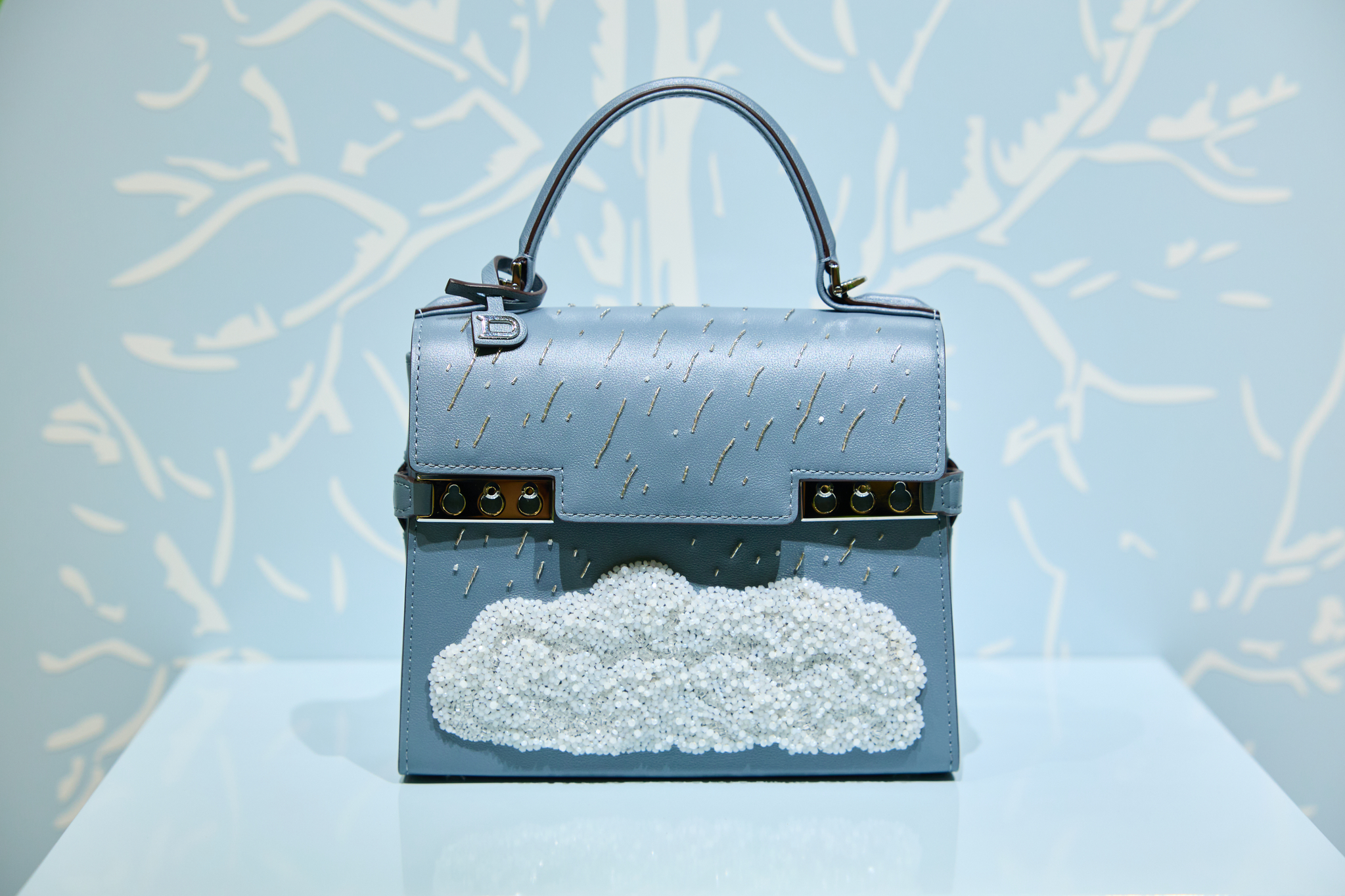 Tempete Le Chant de l'Orage, inspired by Surrealist artist Rene Magritte's (1898-1967) painting of the same title, also known as ″Song of the Storm″ (1937) in English. This model is adorned with hand-embroidered embossed pearls. [DELVAUX]