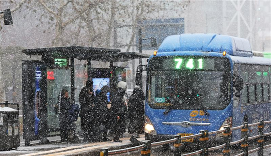 People wait for the bus in the snow in Jongno District, central Seoul, on Feb. 6. Heavy snow advisories were issued in most of the country on Thursday, with some commuters worried over whether they could arrive home.[NEWS1]