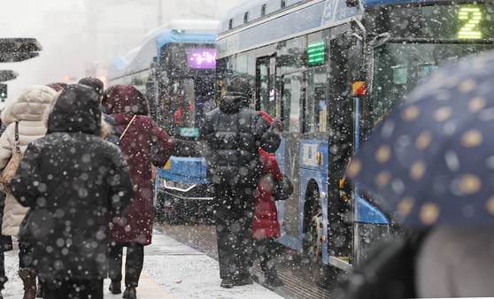 People wait for the bus in the snow in Jongno District, central Seoul, on Feb. 6. Heavy snow advisories were issued in most of the country on Thursday, with some commuters worried over whether they could arrive home. [NEWS1]