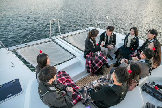Participants in Seoul's mass blind date event chat during a yacht tour on the Han River in November. [SEOUL METROPOLITAN GOVERNMENT]