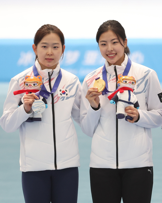 Kim Min-sun, left, and Lee Na-hyun pose with their silver and gold medals, respectively, after the women's 100-meter speed skating race in Harbin, China, on Feb. 8 [YONHAP]