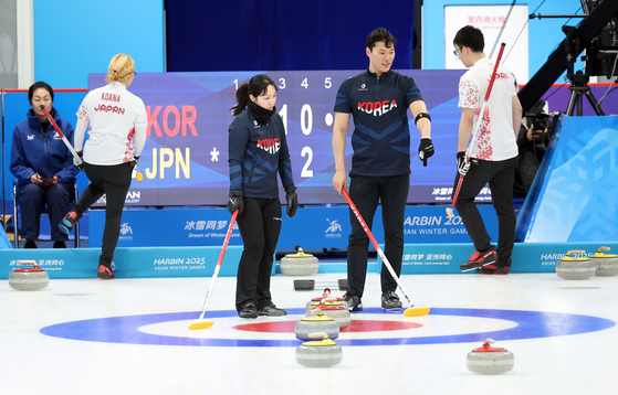 Korean curlers Kim Kyeong-ae, center left, and Seong Ji-hoon, center right, compete in the mixed doubles final against Koana Tori and Aoki Go of Japan at Harbin Pingfang District Curling Arena in Harbin, China on Feb. 8. [YONHAP] 