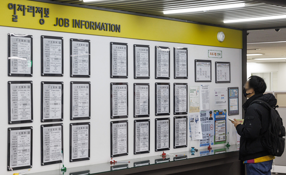 A job-seeker checks postings on a job board at an Employment Welfare Plus Center in Seoul on Feb. 10. [YONHAP]