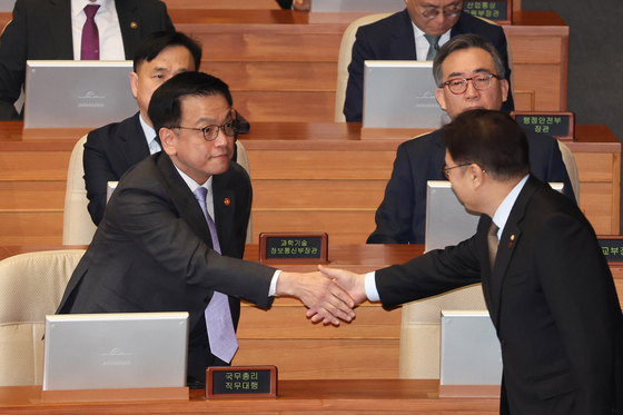 Acting President Choi Sang-mok, left, and National Assembly Speaker Woo Won-shik shake hands during a plenary session at the National Assembly in Yeouido, western Seoul, on Feb. 10. [YONHAP] 
