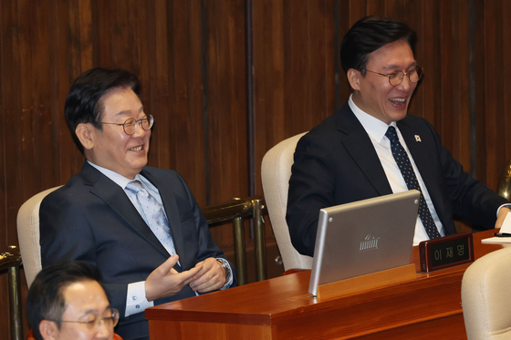 Democratic Party leader Rep. Lee Jae-myung, left, laughs as he listens to People Power Party floor leader Rep. Kweon Seong-dong's speech at the National Assembly in Yeouido, western Seoul, on Feb. 11. [NEWS1] 